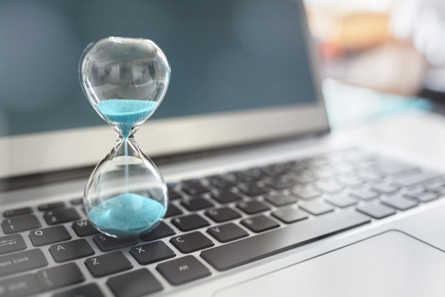 Hourglass sitting on a laptop counting down the time