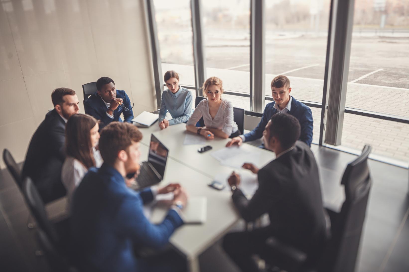 Briefing team and executive management holding a meeting at a conference table