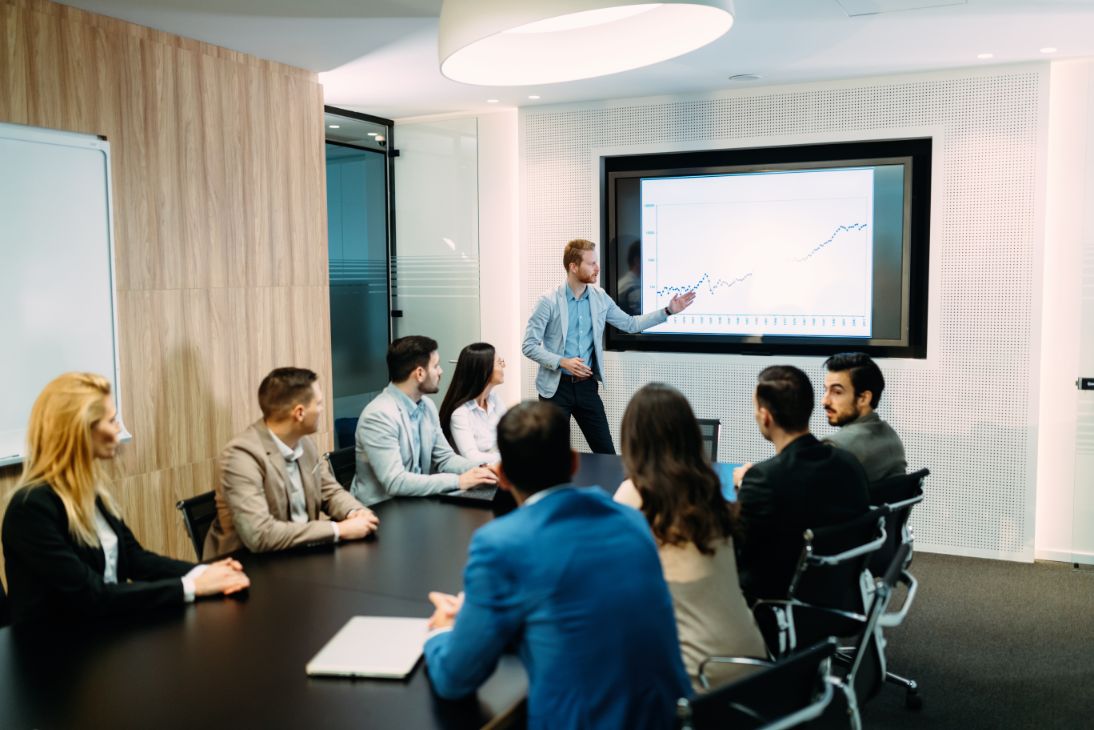Business person giving a presentation at the front of a conference room