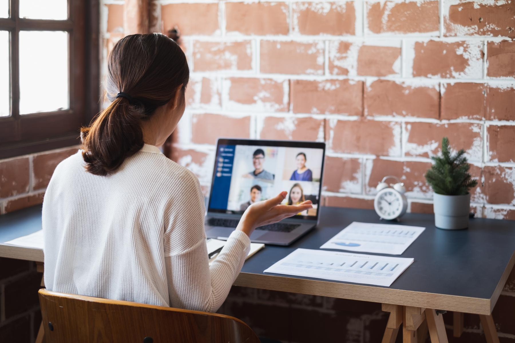 Woman sitting at her desk on the computer in a virtual executive briefing 